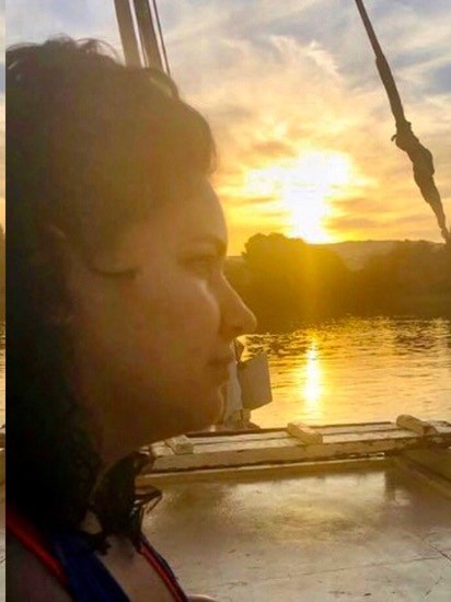 Profile of Amparo Ostojic looking out onto water with the sun setting